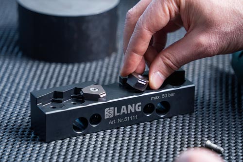 Positionierung von Makro-4Grip Prägeeinsätzen in einer Prägebacke.